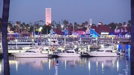 Lighthouse and harbor docks at Long Beach with palm trees and calm waters in view