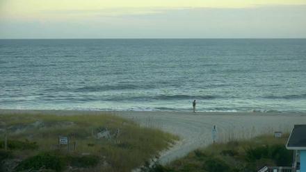 Wide ocean view from Holden Beach looking toward shoreline and horizon under a soft sky