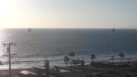 Panoramic ocean view from above El Porto Overlook, with waves breaking along the shore and beach scenery below.
