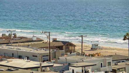 A sunset-tinged view of the Pacific from El Porto’s Rosecrans Overlook with ocean waves and silhouetted skyline.