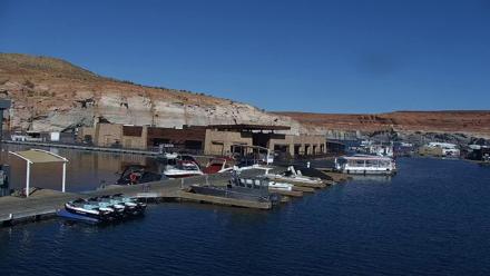 Boats moored at Antelope Point Marina on Lake Powell with sandstone cliffs and serene water reflections