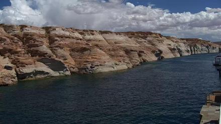 Boats moored at Antelope Point Marina on Lake Powell with sandstone cliffs and serene water reflections