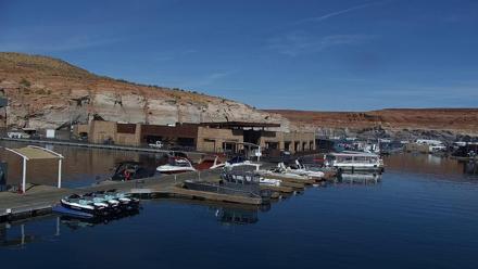 Boats moored at Antelope Point Marina on Lake Powell with sandstone cliffs and serene water reflections