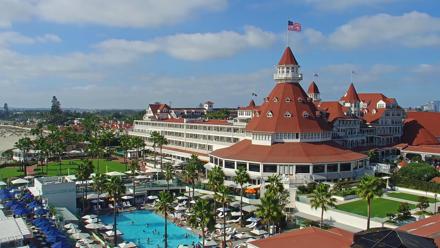 Roaming 4K view of Hotel del Coronado, Victorian red turrets, beach and Pacific shoreline in Coronado, California.