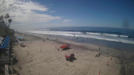 View of Del Mar Beach from bluff level showing waves, sand, and a mounted PTZ camera in the foreground